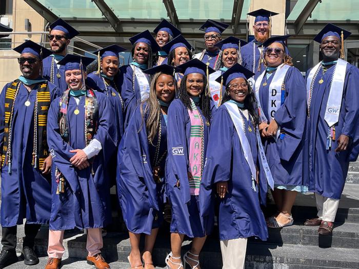 The first cohort of the GSEHD Educational Leadership and Administration program posed for photos their graduation attire in front of Gelman Library.