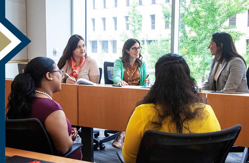 GSEHD faculty member and students having a discussion in the classroom