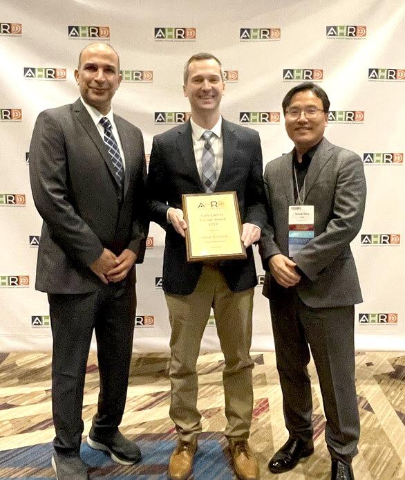 Dr. Oliver (Ozzie) Crocco (center) is awarded the Early Career Scholar Award