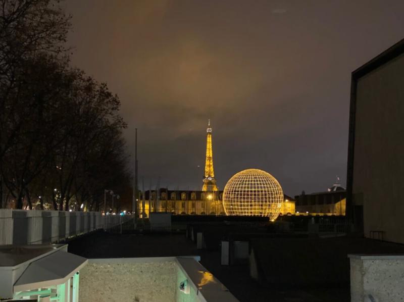 view of the Eiffel Tower lit up at night in the distance