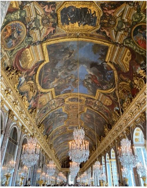 View of ceiling and chandeliers in corridor of Versailles