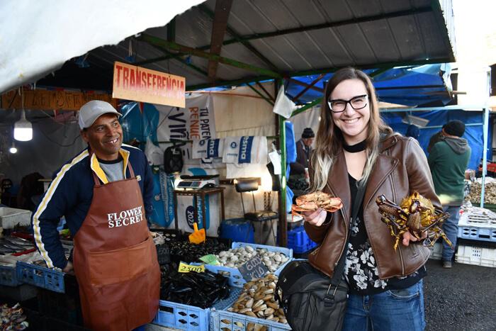 Caroline poses for photo holding her purchases at the Valparaíso fish market