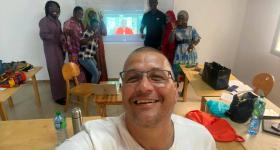 participants in Senegal pose for a group photo while one member takes a "selfie" of the group